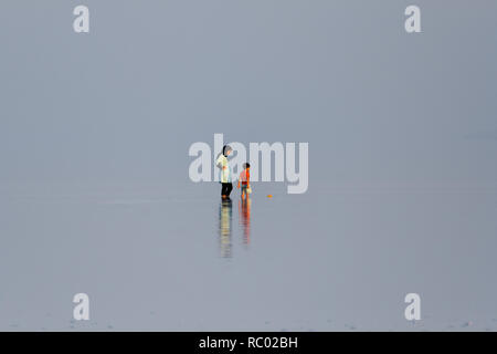 Una donna sta camminando con il suo bambino in Salt Lake Urmia, West Azerbaijan provincia, Iran Foto Stock