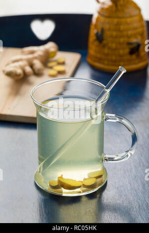 Bicchiere di vetro con un sano tè allo zenzero e miele Foto Stock