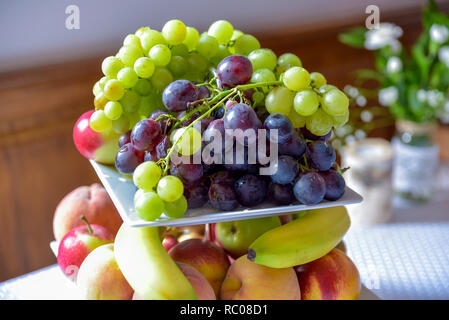 Un cesto di frutta è riempito con una varietà di prodotti colorati. Foto Stock