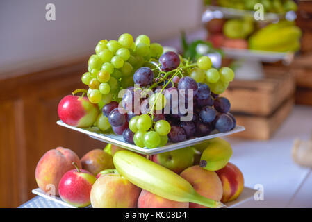 Un cesto di frutta è riempito con una varietà di prodotti colorati. Foto Stock