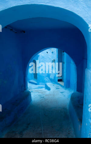 Vicolo con archi in Chaouen, la cosiddetta città blu, una bellissima città nel nord del Marocco molto visitata da turisti provenienti da tutto il mondo. Foto Stock