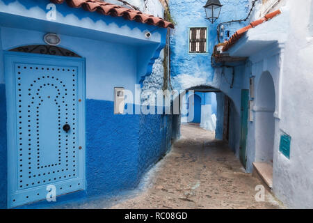 Vicolo con archi in Chaouen, la cosiddetta città blu, una bellissima città nel nord del Marocco molto visitata da turisti provenienti da tutto il mondo. Foto Stock