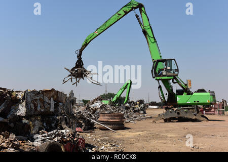 Riciclaggio dei rottami metallici, gru che processano pile di rottami metallici scartati presso un centro di riciclaggio negli Stati Uniti Foto Stock