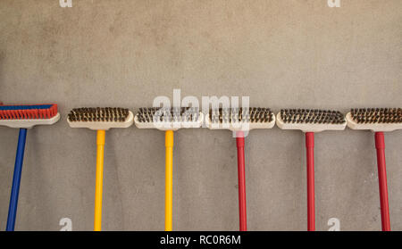 Molti piano spazzola contro la parete dello sfondo. Foto Stock