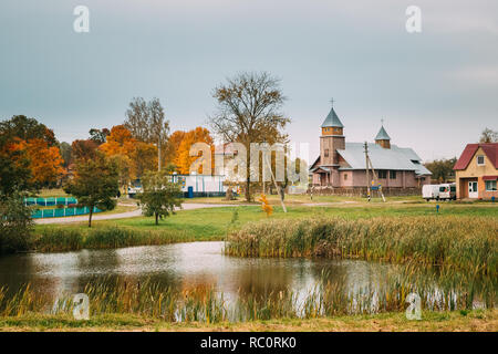 Porplishte, quartiere Dokshitsy ,Vitsebsk Regione, Bielorussia. In legno antico chiesa cattolica della Vergine Maria nella giornata d'autunno. Foto Stock