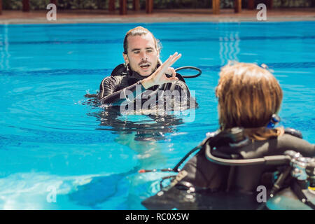 Istruttore subacqueo e studenti. Istruttore insegna agli studenti a immersione. Foto Stock