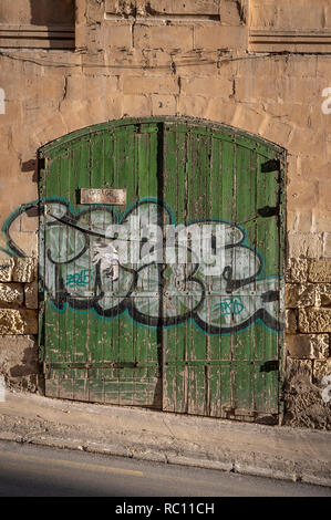 Vecchio weathered verde porta di garage in una strada di Silema, Malta. Foto Stock