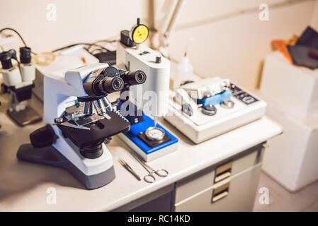 Un esempio di tabella di preparazione in un laboratorio con un microscopio ottico, taglierina ad ultrasuoni sistema e micrometro di precisione macinino macchina di lucidatura Foto Stock