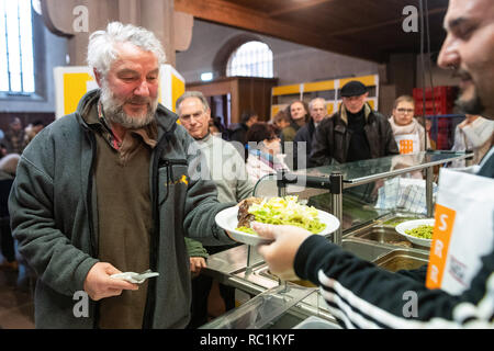 Stuttgart, Germania. Xiii gen, 2019. Marek prende un piatto di cibo durante il primo giorno dei Vespri della Chiesa. Per la venticinquesima volta la più antica chiesa Vesper in Germania fornisce persone bisognose con pasti caldi e più per sette settimane. Credito: Sebastian Gollnow/dpa/Alamy Live News Foto Stock