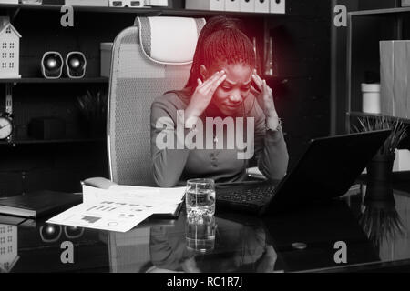 Considerato giovane imprenditrice afro-americano tenendo le mani dietro la testa e lavorare con documenti alla scrivania in ufficio Foto Stock