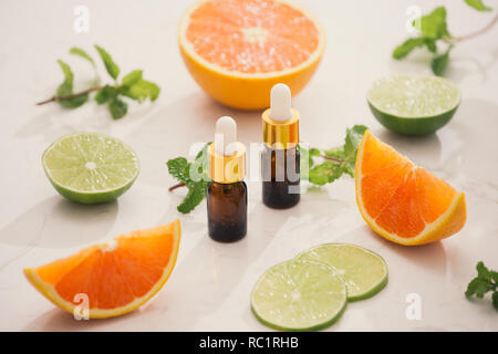 Organici cosmetici con estratti di erbe di limone, arancio, menta su sfondo lucido Foto Stock