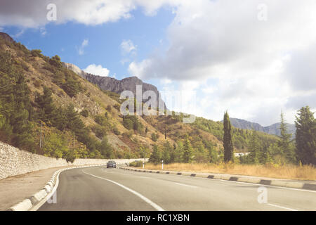 Strada asfaltata su una soleggiata giornata estiva. Montagne di Crimea Foto Stock