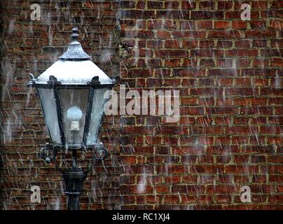 Lampada nella parte anteriore di una parete con i fiocchi di neve Foto Stock