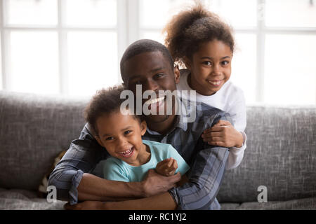 Felice papà africano e di razza mista i bambini a casa ritratto Foto Stock