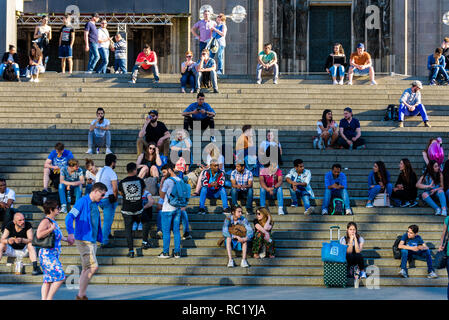 Colonia, Germania. La gente seduta sulle scale accanto alla stazione ferroviaria centrale di Colonia in attesa di treni. Foto Stock