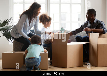 African American kids per aiutare i genitori disimballaggio caselle nella vita Foto Stock