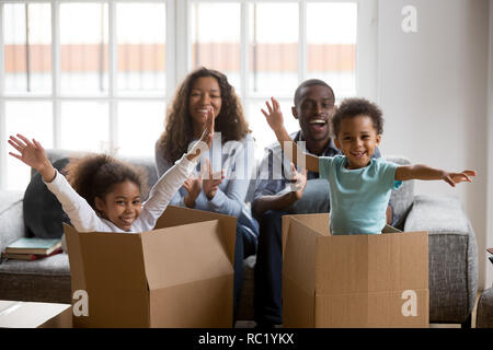 Felice africana di genitori e bambini che giocano nelle caselle godere di delocalizzazione Foto Stock