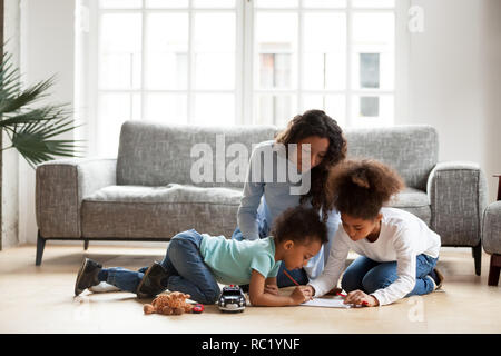 Nero amorevole madre e bambini di disegno con la matita colorata Foto Stock