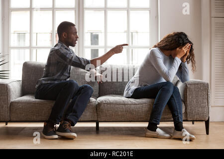 Arrabbiato nero marito sostenendo incolpando sconvolto moglie di problemi Foto Stock