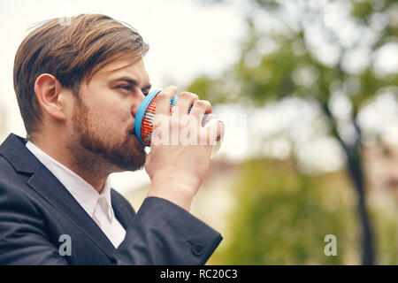 Giovane imprenditore beve caffè mentre va al lavoro Foto Stock