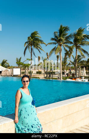 La donna accanto alla piscina in Hotel Al Fanar, Salalah, Dhofar Governatorato, Oman Foto Stock