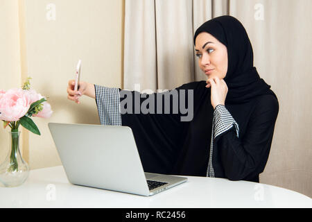 Bellissima giovane donna araba tenendo selfie con il suo telefono cellulare Foto Stock