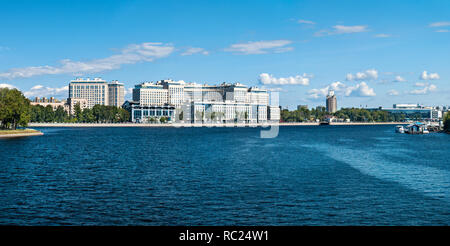 Sulle rive del Bolshoy Nevka fiume sul terrapieno Ushakovskaya sono alti edifici moderni a San Pietroburgo in una giornata di sole sotto un cielo blu wi Foto Stock