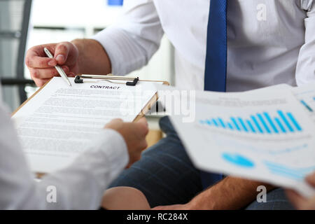 Braccio maschio offerta sotto forma di contratto sul tampone di appunti Foto Stock