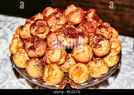 Dolce e saporito pastarelle riempiti con creme assortite collocato su un grande piatto di portata - messa a fuoco selettiva Foto Stock