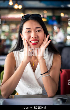 Allegro ragazza asiatica al ristorante ritratto Foto Stock