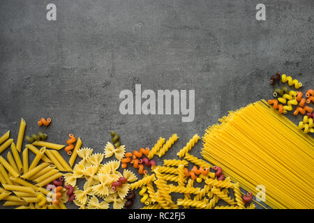 Vari tipi di pasta - Spaghetti, penne, fusilli, colorata vege Foto Stock