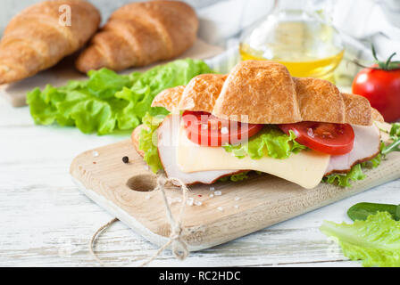 Sandwich croissant con pancetta e formaggio, lattuga e pomodoro Foto Stock