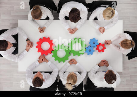 Immagine concettuale di businessteam lavorando in modo coesivo , denti colorati sul tavolo, interazione e unità Foto Stock