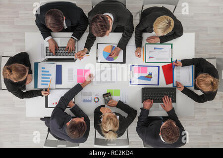 La gente di affari riunione nell'ufficio vista dall'alto , Lavoratori di colletto bianchi discutere i documenti con diagrammi e utilizzando computer portatile Foto Stock