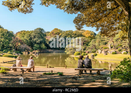 I turisti godono della vista al lago Daiseneni, Giardini Rikugien, Tokyo, Giappone Foto Stock