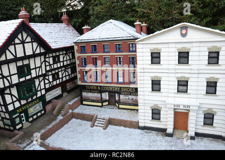 Negozi nella città nuova a Bekonscot Model Village, Beaconsfield, Buckinghamshire, Regno Unito. Neve in inverno. Foto Stock