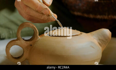 Professional potter maschio lavora in officina, studio - rendendo il bollitore. Immagine ravvicinata di potter con le mani in mano. Fatti a mano, small business, creazione di concetto di lavoro Foto Stock