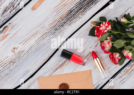 Accessires femmina, di fiori e di posta. Vista superiore, piatto laici. Legno bianco sullo sfondo. Foto Stock