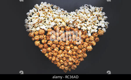 Chi ama il cinema concetto di pop-corn disposti in una forma di cuore. Popcorn assortiti Foto Stock