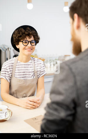 Sorridente barista ascoltando il cliente Foto Stock