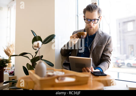 Concentrate l uomo la lettura online prenota in cafe Foto Stock