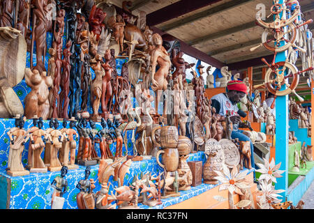 Nassau / Bahamas - Aprile 3.2007: Vista sul workshop locale la visualizzazione di molte figure in legno di un nativo carver lavorando sulla sua scultura in legno. Foto Stock