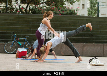 Una giovane donna istruttore yoga insegna le posizioni yoga per donne in una classe gratuita al Parco Woodruff il 18 agosto 2018 a Atlanta, GA. Foto Stock