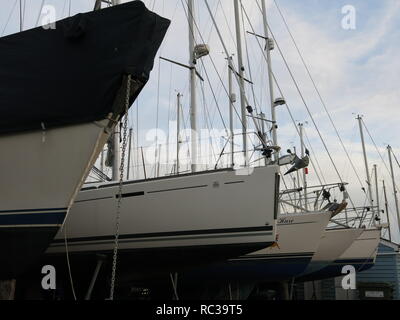 Close-up di cinque yacht ormeggiati in una fila allo Yacht Club sul fiume Deben a Waldringfield, Suffolk; Novembre 2018 Foto Stock