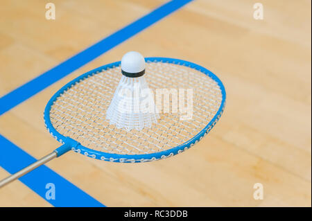 White badminton volano su una sala con pavimento a badminton .close up volani su badminton racchetta a badminton. Foto Stock