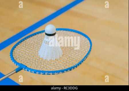 White badminton volano su una sala con pavimento a badminton .close up volani su badminton racchetta a badminton. Foto Stock