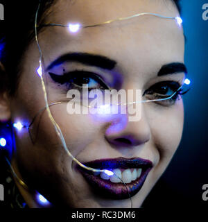 Ragazza giovane con luci sopra la testa Foto Stock