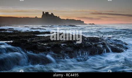 Impostazione di colori sun il cielo dietro il castello dove il mare del Nord crea il movimento e aggiungere la complessità per l'immagine Foto Stock