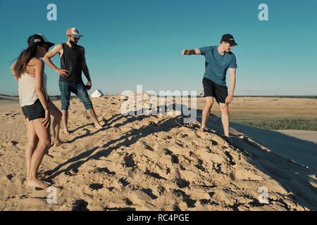 Santa Cruz, Bolivia - Settembre 5 2018: giovani donna e uomo sand boarding al dune di sabbia del deserto vicino alla città Foto Stock