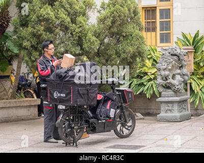 SF urgente consegna tramite corriere uomo consegnare i pacchi di Xiamen Foto Stock